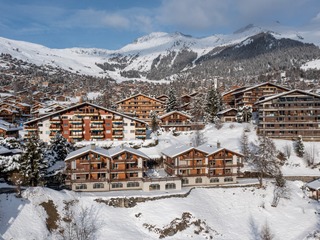 View in winter, Chalet Antika-Vetera, a pair of twin roofed chalets perched on the edge of Verbier's sunny plateau